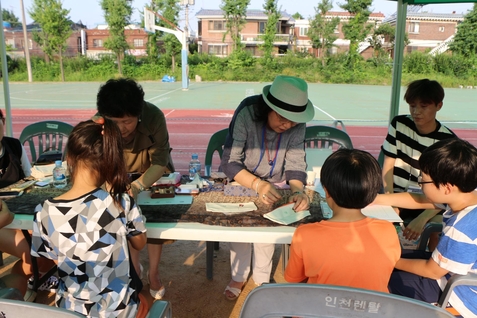 어린이를 대상으로 자수체험 이벤트를 진행하는 모습
